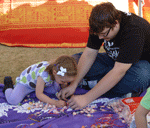picture of young man helping little girl to make a lei of candy