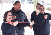 lady laughing while holding a spear, Maori teachers with her and smiling