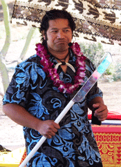 picture of man in coloful shirt holding a Samoan fire knife with large shiny blade
