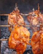 Chicken on rotisserie over charcoal